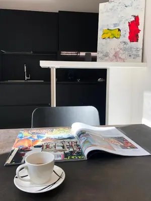 a table with a cup of coffee and a magazine at Romantic Suite Colosseum - Luxury Apartment in Rome