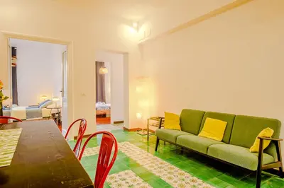 a living room with a green couch and a table at Candia Cento Apartment Vatican Museums in Rome