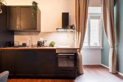 a kitchen with black cabinets and a window at Piacentino Homes Re di Roma apartment in Rome