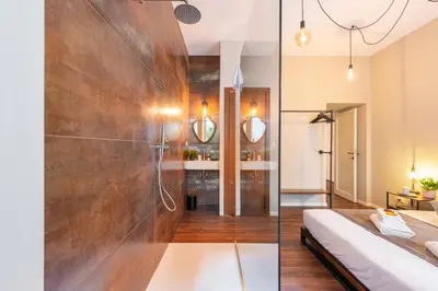a bathroom with a shower and a bed in a room at Piacentino Homes Re di Roma apartment in Rome