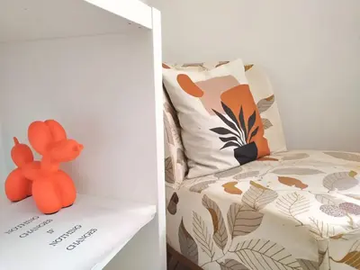 a small orange teddy bear sitting on a shelf next to a bed at Vatican Garden Oasi in Rome