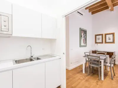 a kitchen with a sink and a table with chairs at Trastevere Luxury Bright Apartment in Rome