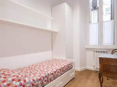 a white bedroom with a bed and a window at Trastevere Luxury Bright Apartment in Rome