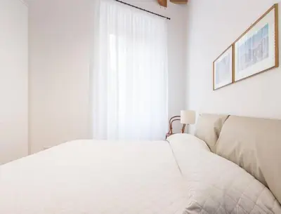 a white bedroom with a bed and a window at Trastevere Luxury Bright Apartment in Rome
