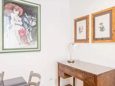 a desk in a room with three pictures on the wall at Trastevere Luxury Bright Apartment in Rome