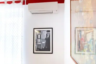 a white wall with a picture and a air conditioner at Perla - Cozy Apartment in Piazza Navona in Rome