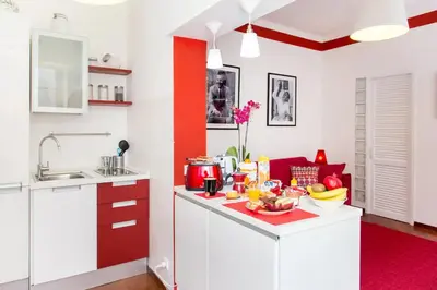 a kitchen with red and white cabinets and a table with food on it at Perla - Cozy Apartment in Piazza Navona in Rome