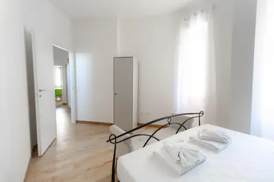 a white bedroom with a bed and a mirror at Trastevere four seasons Feltre in Rome