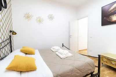 a bedroom with a bed with yellow pillows on it at Trastevere four seasons Feltre in Rome