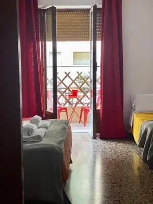 a bedroom with two beds and a door to a balcony at MM Ma Maison in Rome