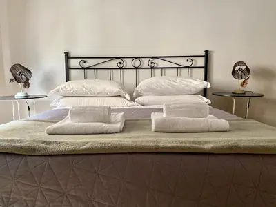 a bed with four pillows and two tables at MM Ma Maison in Rome