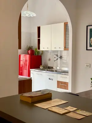 a kitchen with white cabinets and a red refrigerator at MM Ma Maison in Rome