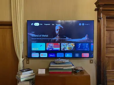 a flat screen tv hanging on a wall with books at 78 Luxury Margutta Suite in Rome