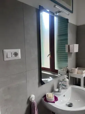 a white bathroom with a sink and a mirror at Ranieri casa vacanze in Rome