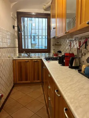 a kitchen with wooden cabinets and a sink and a window at Colosseum Dream Apartment in Rome