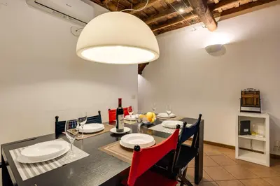 a dining room with a table and a large light fixture at Colosseum Dream Apartment in Rome