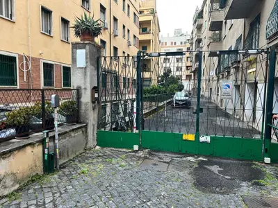 a green gate in a city with buildings at Domus Euclide in Rome