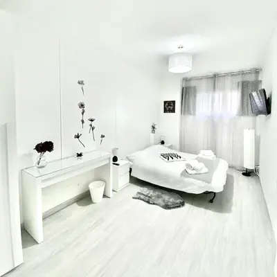 a white bedroom with a bed and a mirror at Domus Euclide in Rome