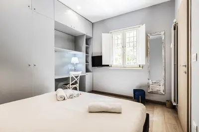 a bedroom with a large white bed and a window at Videnda Colosseo in Rome