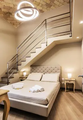 a bedroom with a large bed with a staircase at Videnda Colosseo in Rome