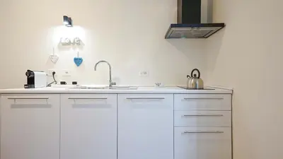 a kitchen with white cabinets and a sink at EasyTopStay - Crescenzio Elegant Apartment in Rome