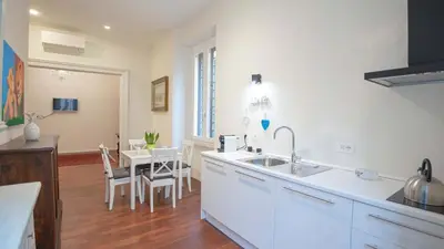 a kitchen with a sink and a table with chairs at EasyTopStay - Crescenzio Elegant Apartment in Rome