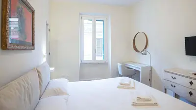 a white bedroom with a bed and a desk and a mirror at EasyTopStay - Crescenzio Elegant Apartment in Rome