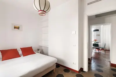 a bedroom with a white bed with red pillows at Welcome to Vatican in Rome