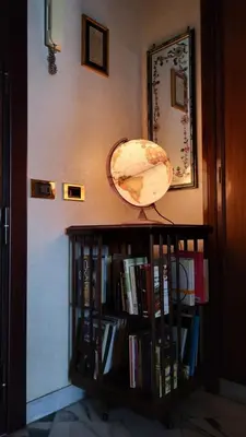 a book shelf with books and a globe on it at In Vacanza dai Nonni in Rome