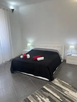a bedroom with a large bed with two red pillows at Nic trastevere house in Rome