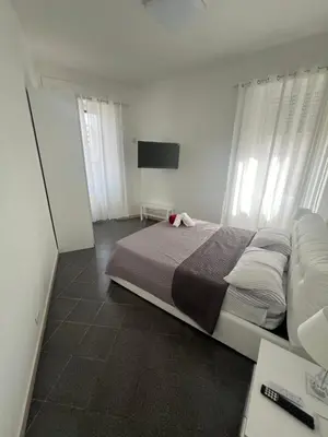 a bedroom with a large bed and a flat screen tv at Nic trastevere house in Rome