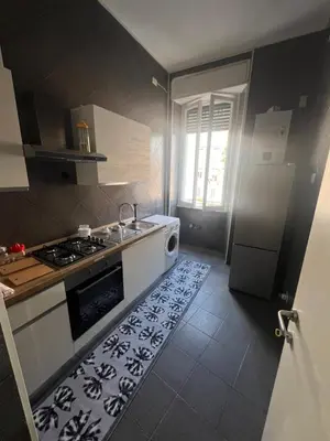 a kitchen with a stove and a sink with a rug at Nic trastevere house in Rome