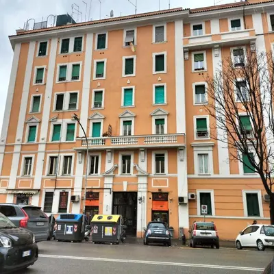 a large building with cars parked in front of it at Nic trastevere house in Rome