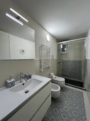 a white bathroom with a sink and a toilet at Residenza Santi ai Monti in Rome