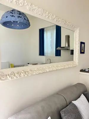 a mirror on a wall with a couch in a room at Residenza Santi ai Monti in Rome