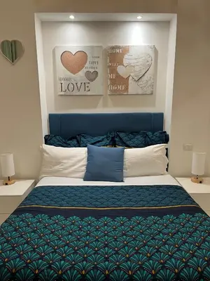 a bedroom with a bed with a blue head board at Residenza Santi ai Monti in Rome