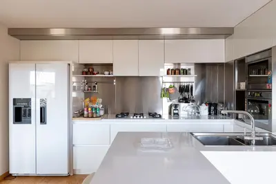 a kitchen with white cabinets and a white refrigerator at Restart Accommodations Moro in Rome