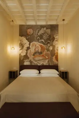 a bedroom with a large bed with a painting on the wall at Restart Accommodations Tritone in Rome