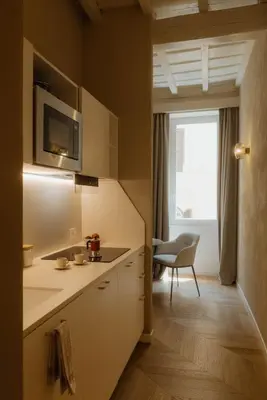 a kitchen with white cabinets and a window at Restart Accommodations Tritone in Rome