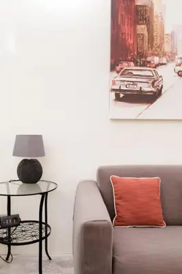 a living room with a couch and a picture of a car at Restart Accommodations Nettuno in Rome