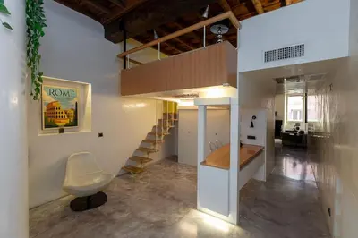 a living room with a stair case and a chair at Restart Accommodations Nettuno in Rome
