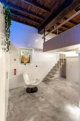 a white chair in a room with a staircase at Restart Accommodations Nettuno in Rome