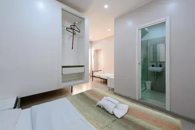 a bathroom with white walls and a large mirror at Guesthouse o Affittacamere Casa Barberini in Rome