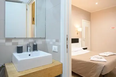 a bathroom with a sink and a bed at Guesthouse o Affittacamere Casa Barberini in Rome