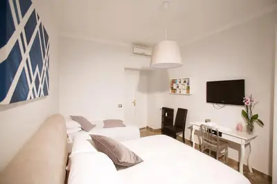 a living room with a white couch and a desk at Comfort in Centro, benvenuti nella Cosy House in Rome