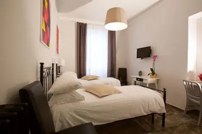 a bedroom with two beds and a desk and a television at Comfort in Centro, benvenuti nella Cosy House in Rome