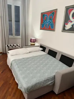 a bedroom with a bed and a couch at La casa di Monica appartamento Ostiense Roma in Rome