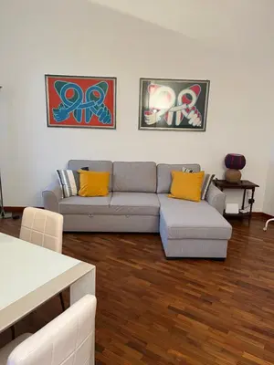 a living room with a gray couch and yellow pillows at La casa di Monica appartamento Ostiense Roma in Rome