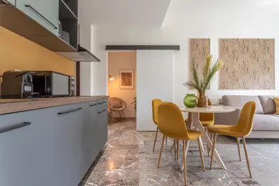 a kitchen and living room with a table and chairs at Cornelia cozy home in Rome
