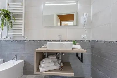 a bathroom with a sink and a tub and a mirror at Cornelia cozy home in Rome
